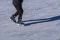 Closeup of legs of ice skater on outdoor ice rink