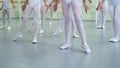 Closeup legs of little ballerinas group in white shoes practicing in ballet school slow motion