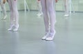 Closeup legs of little ballerinas group in white shoes practicing in ballet school slow motion