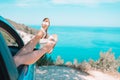 Close up of little girl feet showing from car window background sea Royalty Free Stock Photo