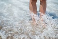 Closeup on legs in sea wave splashes