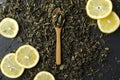 Closeup of lemon slices, wooden spoon full of dery tea leaves, hipe of dery tea on the dark table Royalty Free Stock Photo