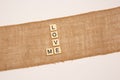 Closeup of letter tiles "Love Me" laying on a natural jute sack cloth isolated on white background Royalty Free Stock Photo