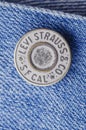 Closeup of Levi Strauss button on blue jeans.