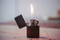 Lighter with flame on wooden table Royalty Free Stock Photo