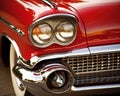 Closeup on the lights and grill to one side of a red classic car. Royalty Free Stock Photo