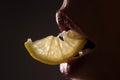 Closeup lips with lemons. Sexy fruit. Vitamin C. Summer refreshment. Girl with slice of lemon. Macro of mouth chewing