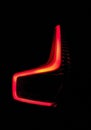 Closeup of a lit red tail light of a car against a dark background Royalty Free Stock Photo