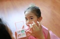 Closeup little Asian ballerina girl with glister makeup by her mother