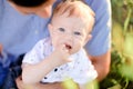 Closeup little baby on father blue t shirt background.