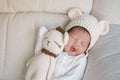 Closeup a baby sleeping comfortably on sofa with bear doll Royalty Free Stock Photo