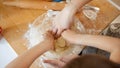 Closeup of little boy with mother kneading biscuit dough in big glass bowl. Children cooking with parents, little chef