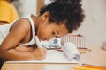 Closeup little child girl black skin writing doing homework at home