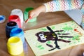 Closeup of little creative toddler girl painting with finger colors an owl bird. Child having fun with drawing at home Royalty Free Stock Photo