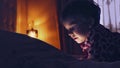 Closeup of a Little cute girl in full darkness watching tablet Royalty Free Stock Photo