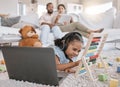 Closeup of a little cute girl using a laptop and wireless headphones while laying on the floor in the lounge. Hispanic Royalty Free Stock Photo