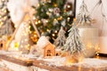 Closeup of little fir with lots of Christmas decoratins behind it. Selective focus