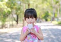 Closeup of little girl drinking milk with straw in the park. Portrait outdoor Royalty Free Stock Photo