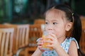 Closeup of little girl drinking Orange juice with looking out Royalty Free Stock Photo