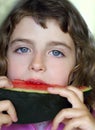 Closeup little girl eating watermelon slice