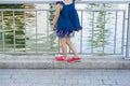 Closeup little girl stands alone on lake bank seeing lake. Concept of risk of falling onto water, kidnap, children sadness... Royalty Free Stock Photo