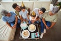 Closeup of a little mixed race boy blowing the candles on a cake at a birthday party with his little brother, parents Royalty Free Stock Photo