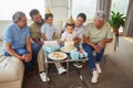 Closeup of a little mixed race boy blowing the candles on a cake at a birthday party with his little brother, parents Royalty Free Stock Photo