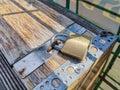 Closeup of a little padlock on a wooden drawer in the sunlight