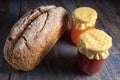 Closeup of loaf of artisan bread and jars of jam Royalty Free Stock Photo