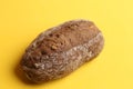 Closeup of a loaf of brown bread isolated on a yellow background Royalty Free Stock Photo