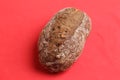 Closeup of a loaf of brown bread with nuts on a red surface Royalty Free Stock Photo