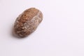 Closeup of a loaf of brown bread with nuts on a white surface Royalty Free Stock Photo