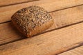 Closeup of a loaf of brown bread with sesame seeds on a wooden table Royalty Free Stock Photo