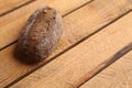 Closeup of a loaf of brown bread on a wooden table under the lights Royalty Free Stock Photo