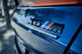 Closeup of the logo of a Blue BMW X6 sports SUV on the backside of the car with a blurry background