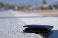 Closeup lost black leather wallet with money drop on the footpath, lost money concept