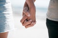 Closeup, love and couple holding hands at a beach for fun, travel and bonding on blurred background. Zoom, hand and man Royalty Free Stock Photo