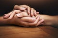 Closeup, love and holding hands for support, comfort and care with grief, loss and empathy. Zoom, people and friends