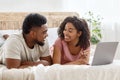 Closeup of lovely black couple lying on bed, using laptop Royalty Free Stock Photo