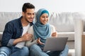 Closeup of loving arab family using laptop at new home