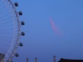 Closeup low angle shot of a Ferris wheel under a blue sunset sky