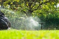 Closeup low angle view of automatic lawn sprinkler watering Royalty Free Stock Photo