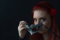 Portrait of redhead attractive young woman holding carnival mask in front of her face Royalty Free Stock Photo