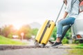 Closeup lower body of woman leg relaxing on car trunk with trolly luggage along road trip with autumn mountain hill background. Royalty Free Stock Photo