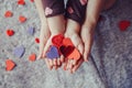 Macro of child with adult parent hands palms holding a bunch of small red and purple paper foam hearts Royalty Free Stock Photo