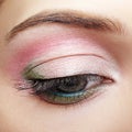 Closeup macro image of human woman eye with pink and green makeup Royalty Free Stock Photo