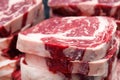 Closeup macro pieces ribeye marbled beef steak on red plastic cutting board on metal table in restaurant kitchen. Concept packing