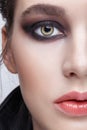 Closeup macro portrait of female face. Girl with perfect skin, green pistachio colour eyes and violet - black smoky eyes make-up Royalty Free Stock Photo