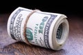 Closeup, macro of rolled American dollar banknotes. Wooden background