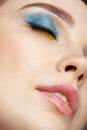 Closeup macro shot of human female face with eyes closed, yellow liner and blue eyes shadows Royalty Free Stock Photo